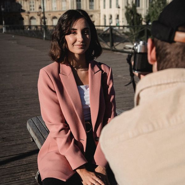 A focused woman smiling after a meditation session in an urban park.